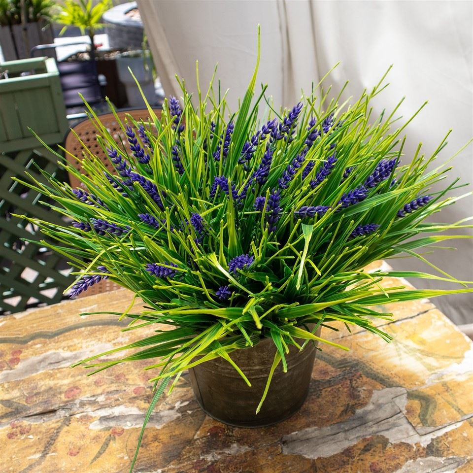 Simulação de grama de junco em vaso com flor roxa e folhas verdes para decoração interna e externa